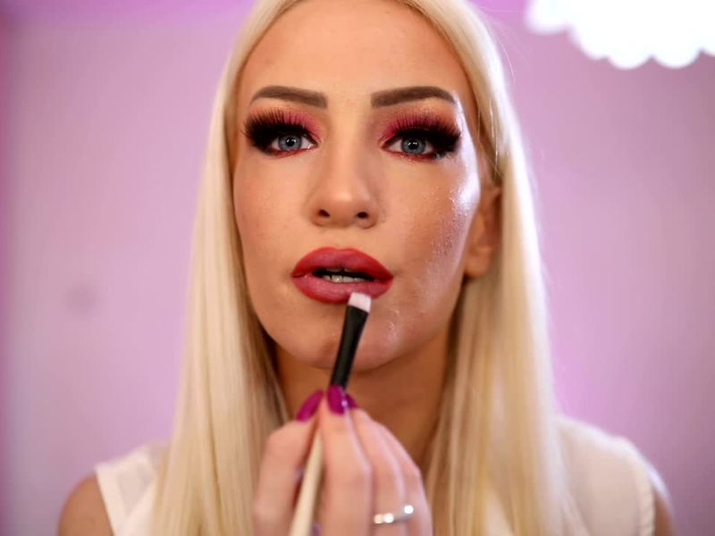 devojka stavlja karmin na usne