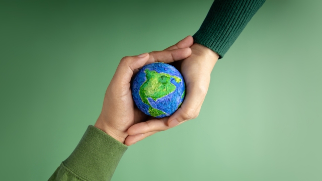 Dve ruke drže malu maketu Zemlje, simbolizujući navike koje prave razliku za ljude i planetu