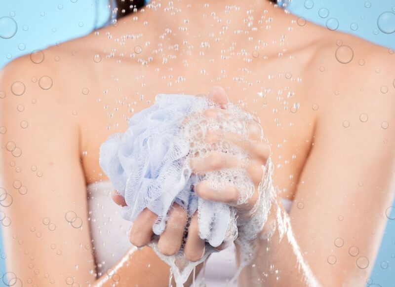 prikaz devojke sa spužvicom za tuširanje u ruci pod tušem