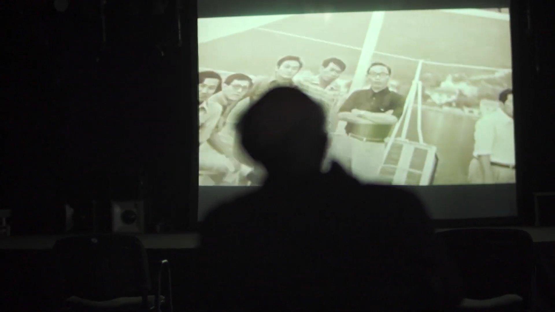 Silueta gledaoca ispred bioskopskog platna tokom filmske projekcije.